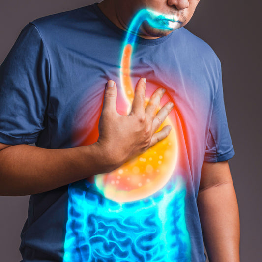 A person in a blue shirt holds their chest, with a colorful graphic overlay showing the digestive system, including the stomach and intestines, suggesting a focus on health or digestion.