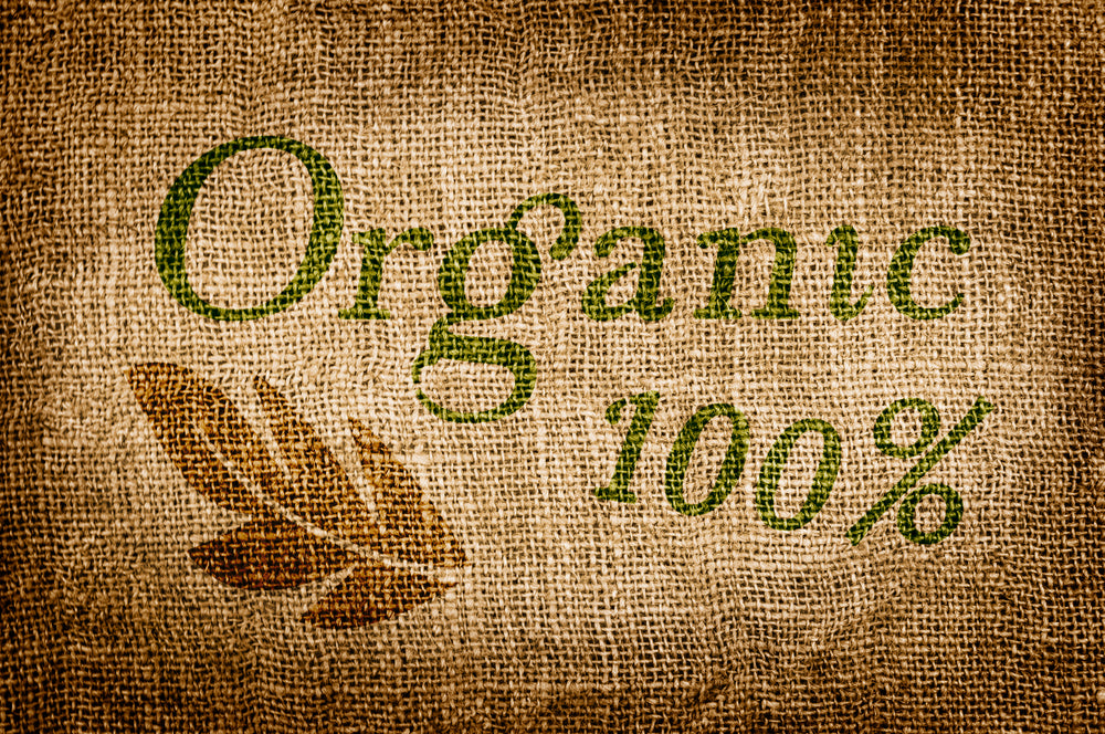 The textured burlap background features the words "Organic" in green and "100%" in a darker shade, accompanied by a brown leaf graphic, emphasizing a natural and eco-friendly theme.
