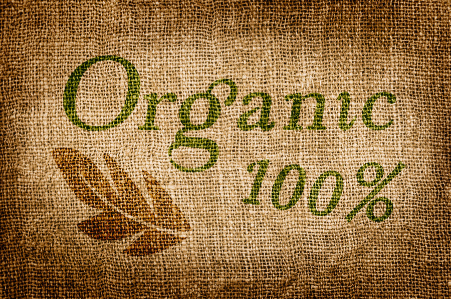 The textured burlap background features the words "Organic" in green and "100%" in a darker shade, accompanied by a brown leaf graphic, emphasizing a natural and eco-friendly theme.
