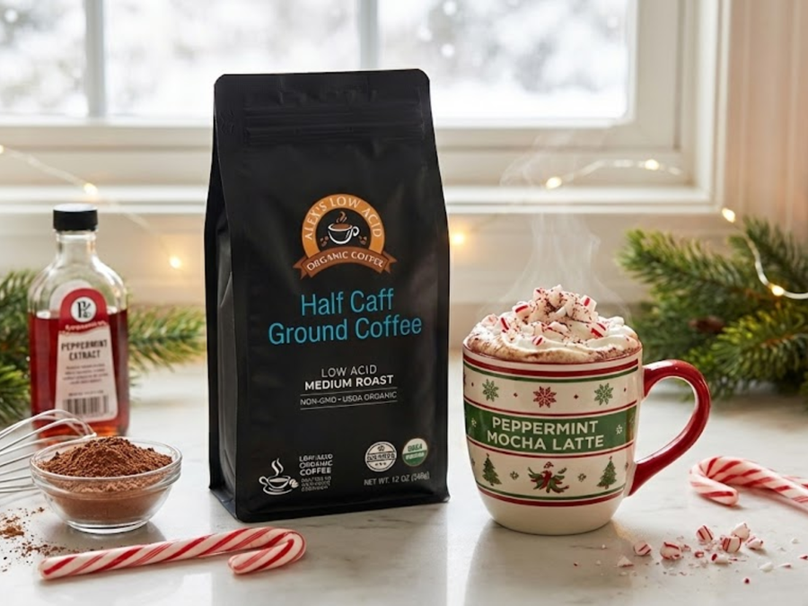 A steaming peppermint mocha latte topped with crushed candy canes sits next to a bag of low-acid coffee and a bottle of peppermint extract, with festive decorations in a cozy kitchen setting.