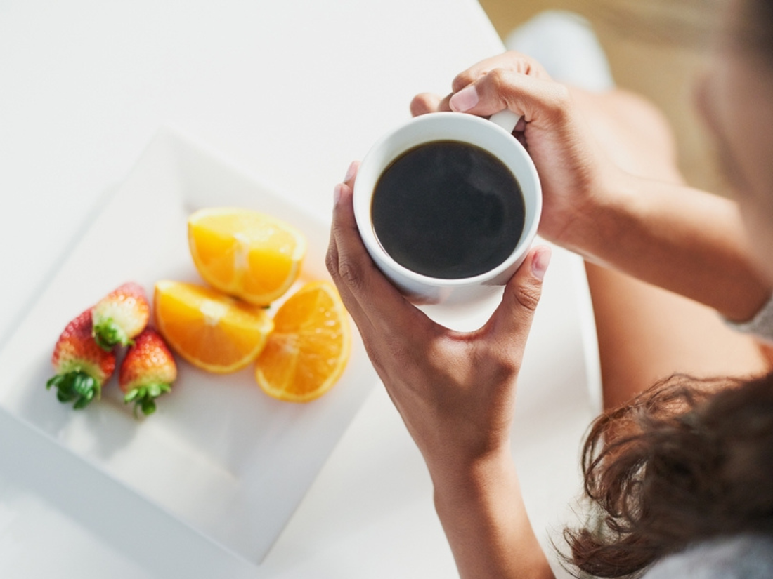 Cup of Alex’s Low-Acid Coffee surrounded by fresh berries and nuts