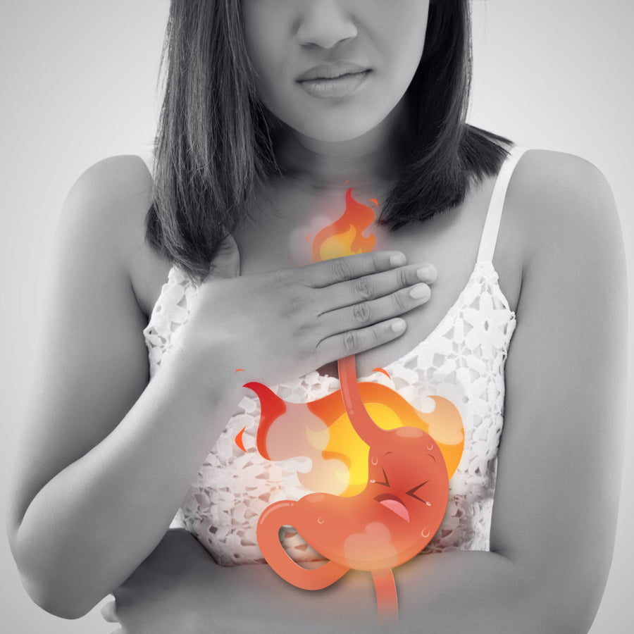 A woman in a white tank top places her hand on her chest, looking concerned, while a cartoonish illustration of a burning stomach is superimposed over her midsection, depicting discomfort.