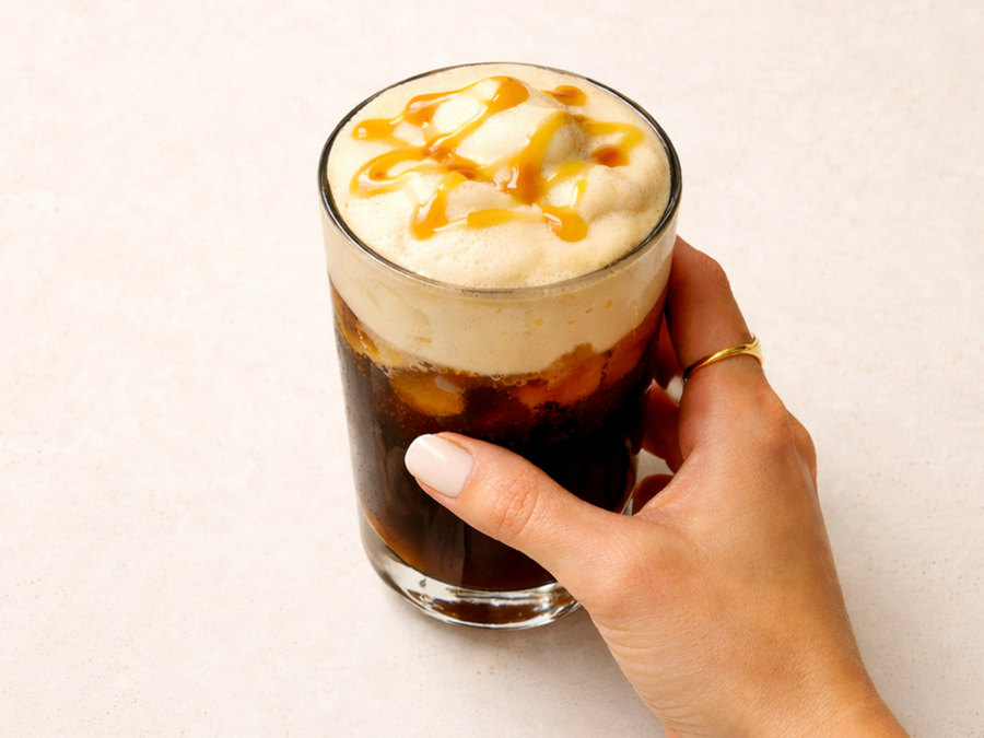 Caramel cold foam cold brew made with Alex’s Low Acid Organic French Roast in a clear glass over ice.