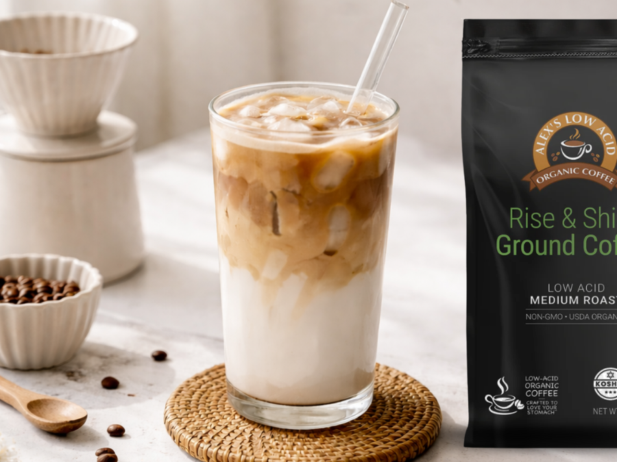 Tall glass of spring-inspired iced low-acid latte topped with cold foam and citrus zest on a bright kitchen counter.