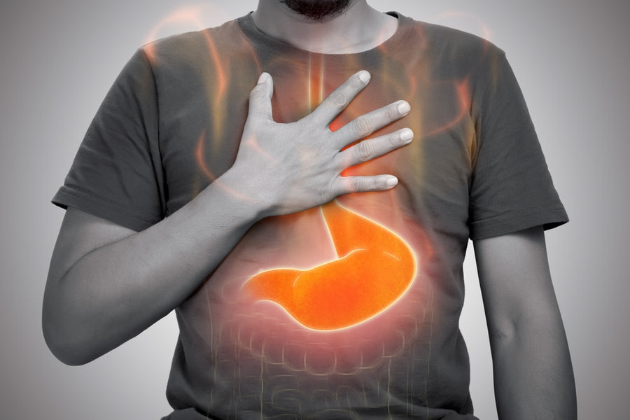 A person with a beard is holding their chest with one hand, while an orange outline of a stomach is superimposed on their shirt, set against a gray background.