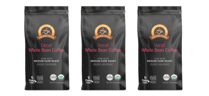 Three bags of Alex's Low-Acid Organic Coffee™ Decaf Whole Bean (12oz) by Alex's Low Acid Coffee, labeled low acid for heartburn relief, medium dark roast, non-GMO, and USDA organic, are displayed upright against a light background.