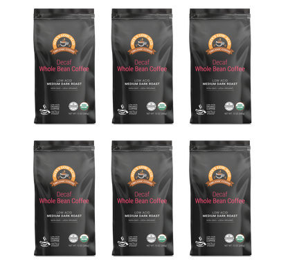 Six black bags of Alex's Low-Acid Organic Coffee™ - Decaf Whole Bean (12oz) by Alex's Low Acid Coffee are shown in two rows, each with an orange and brown label highlighting low acid for heartburn relief and a medium dark roast.