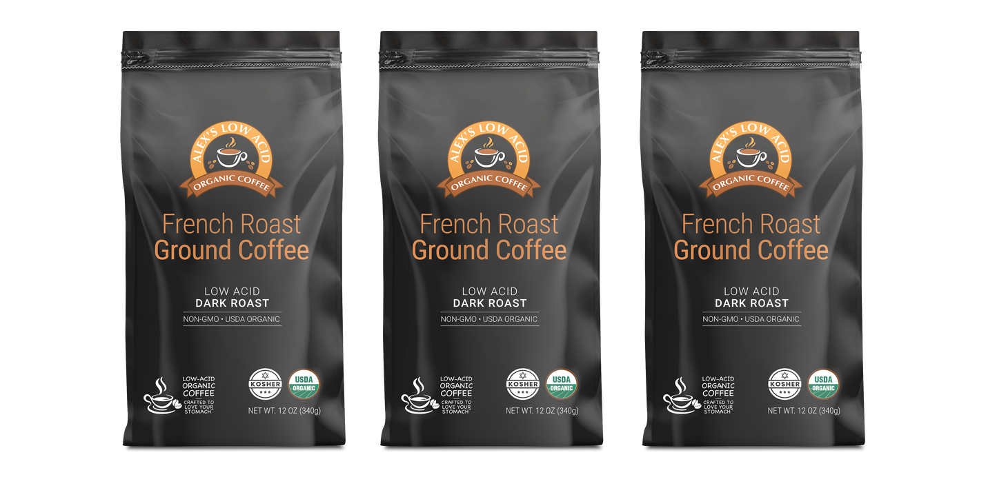 Three black bags of Alex's Low-Acid Organic Coffee™ - French Roast (12oz) from Alex's Low Acid Coffee are lined up, each with an orange and white label stating "Low Acid, Dark Roast, Non-GMO, USDA Organic"—ideal for low acid coffee enthusiasts.