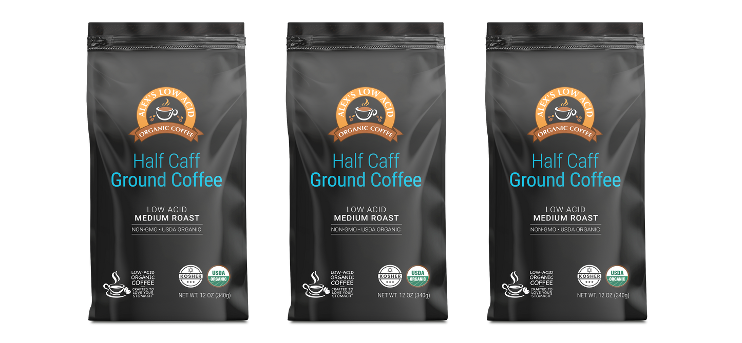 Three black bags of Alex's Low-Acid Organic Coffee™ - Half Caff Fresh Ground (12oz) from Alex's Low Acid Coffee offer a medium roast that's low acid, organic, non-GMO, and herb-organic with a coffee cup icon and bold orange-blue text on the front.