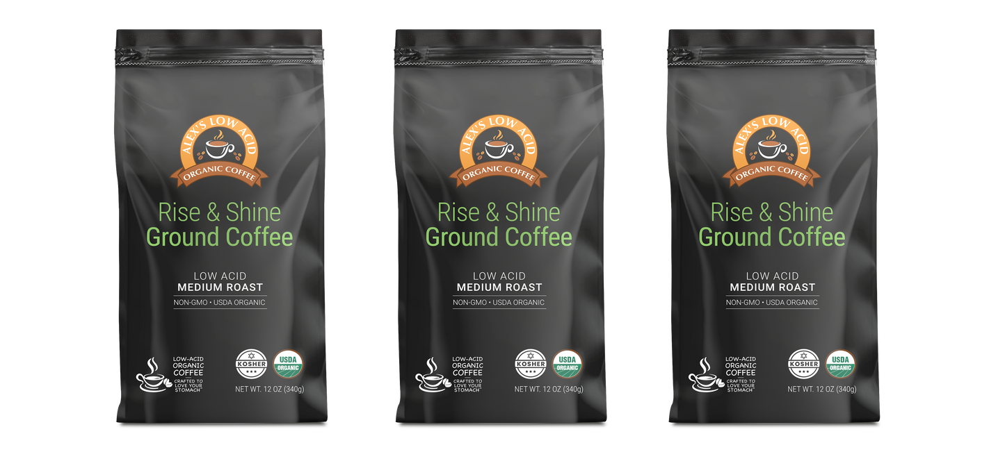 Three black bags of Alex's Low-Acid Organic Coffee™ - Rise and Shine Fresh Ground (12oz) by Alex's Low Acid Coffee are displayed side by side, each featuring green and white text, brown-orange seals, USDA Organic certification, and a low-acid formula.
