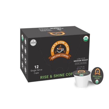 Alex's Low-Acid Organic Coffee™ Single Serve Cups - Rise & Shine (12 count) by Alex's Low Acid Coffee, medium roast. The black box features an orange-brown logo, kosher and USDA organic labels. Two low-acid pods are shown beside the box.